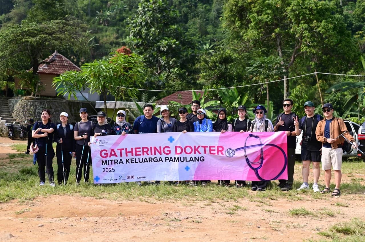Foto grup peserta gathering dokter dengan spanduk di titik awal pendakian.