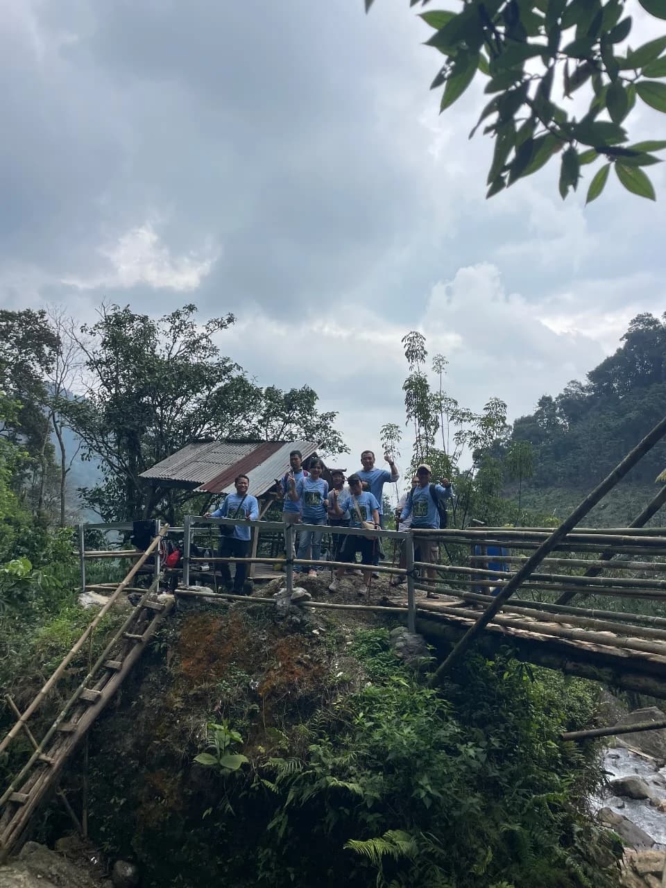 Dua peserta pria menikmati kesegaran air di kolam alami di bawah air terjun.