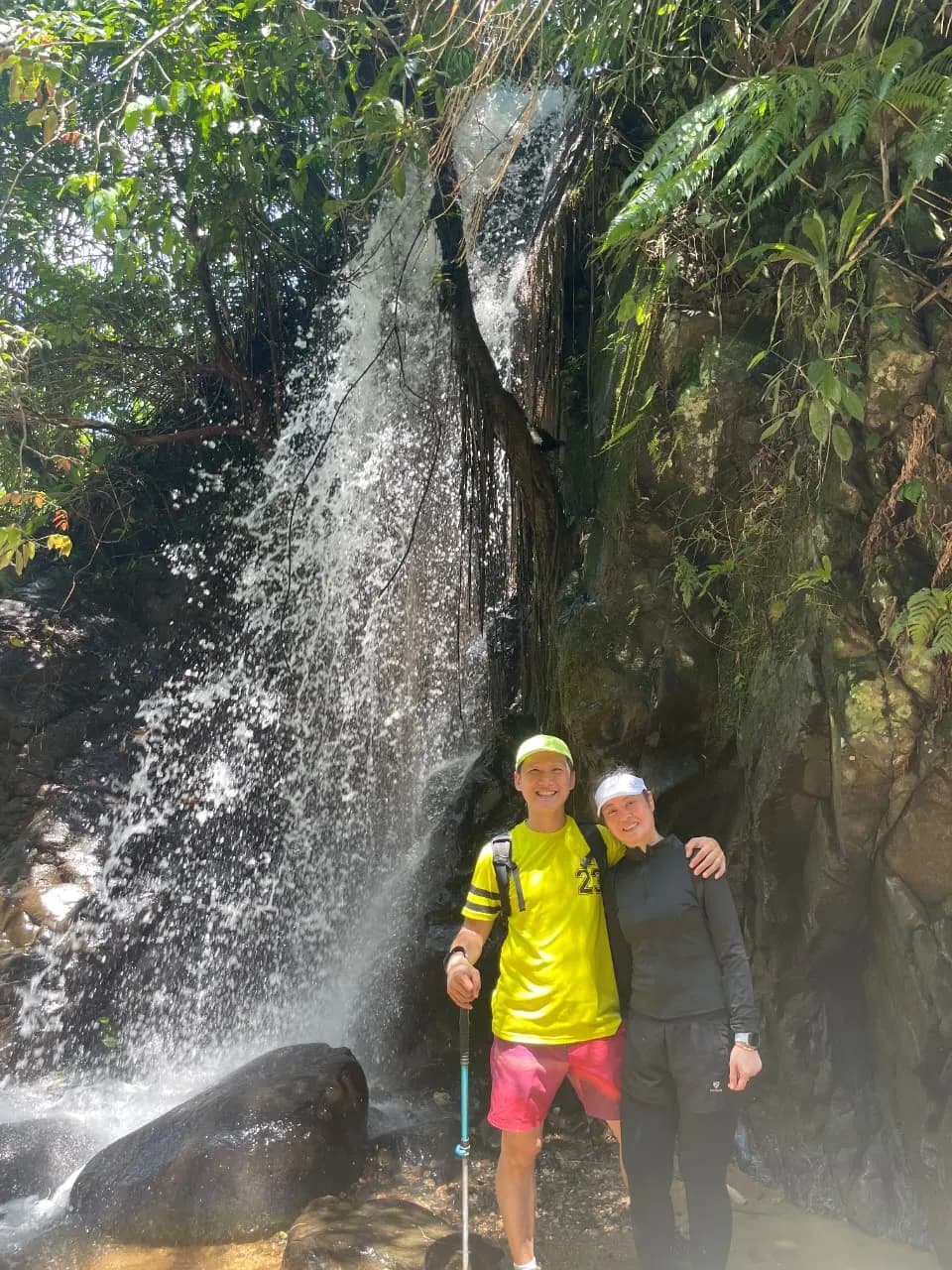 Empat orang peserta sedang mendaki jalur tanah yang menanjak di tengah hutan lebat.