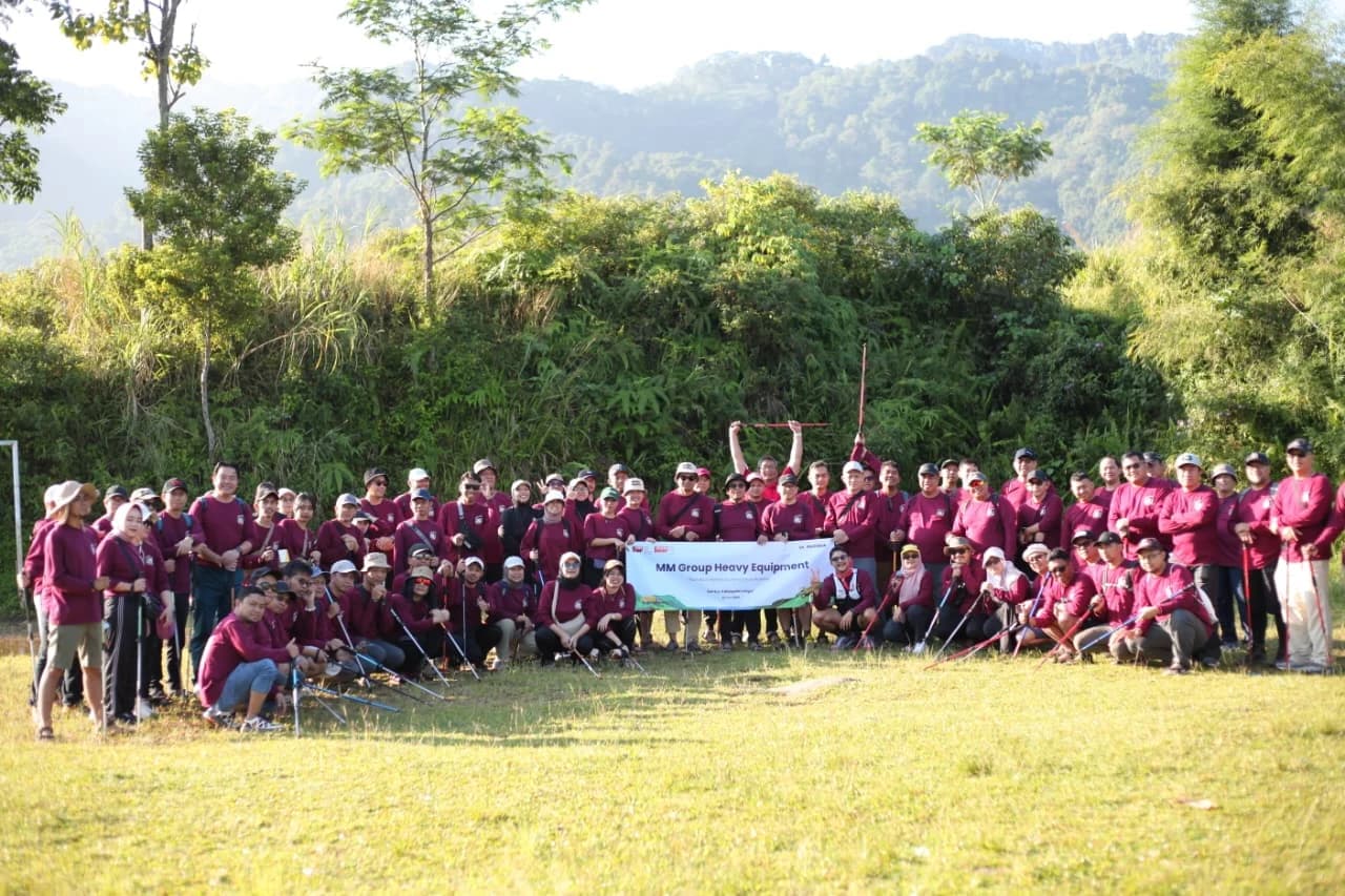 Rombongan peserta dengan hati-hati menyeberangi aliran sungai yang berbatu.