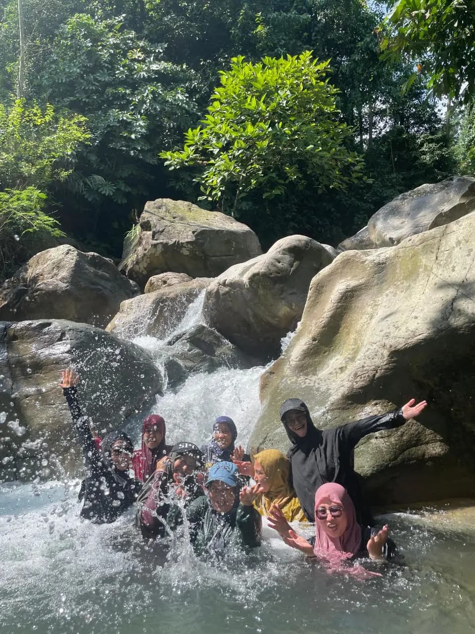 Empat orang peserta sedang mendaki jalur tanah yang menanjak di tengah hutan lebat.