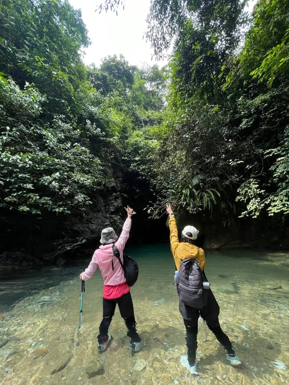 Tiga sahabat berpose di atas batu di kolam curug yang airnya berwarna biru kehijauan.