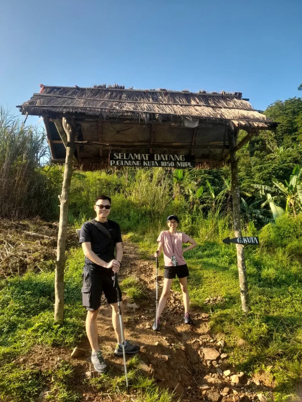 Seorang pendaki pria dengan gagah mengibarkan bendera merah putih di Puncak Kuta.