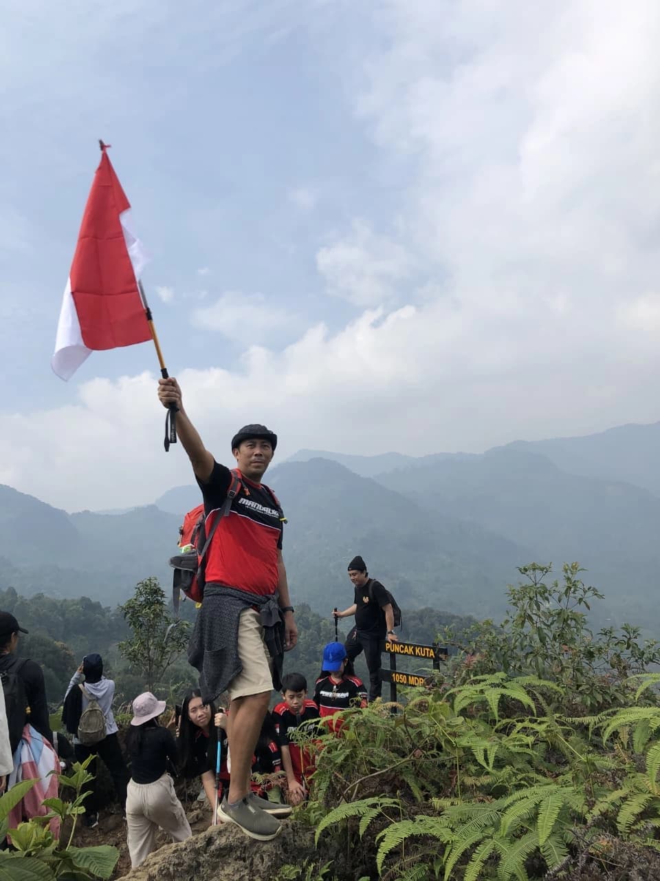 Sepasang peserta berpose di depan curug yang indah di tengah hutan.